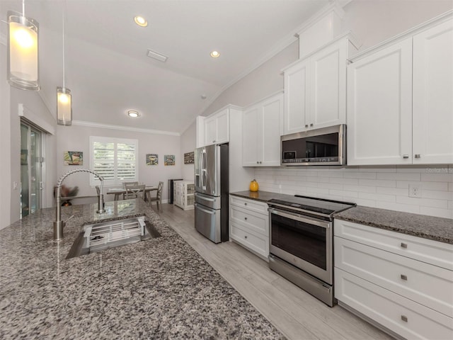 kitchen with white cabinets, appliances with stainless steel finishes, pendant lighting, and a sink