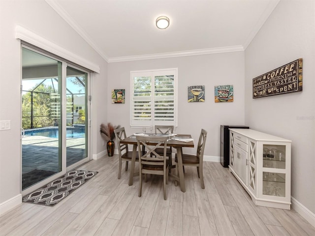 dining area featuring light wood-type flooring, crown molding, and baseboards