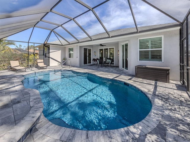 pool with a patio, glass enclosure, and a ceiling fan