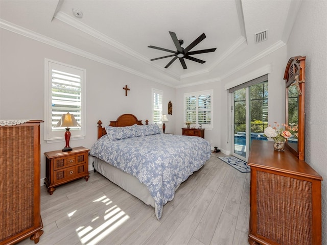 bedroom with visible vents, light wood-style floors, access to exterior, multiple windows, and a tray ceiling