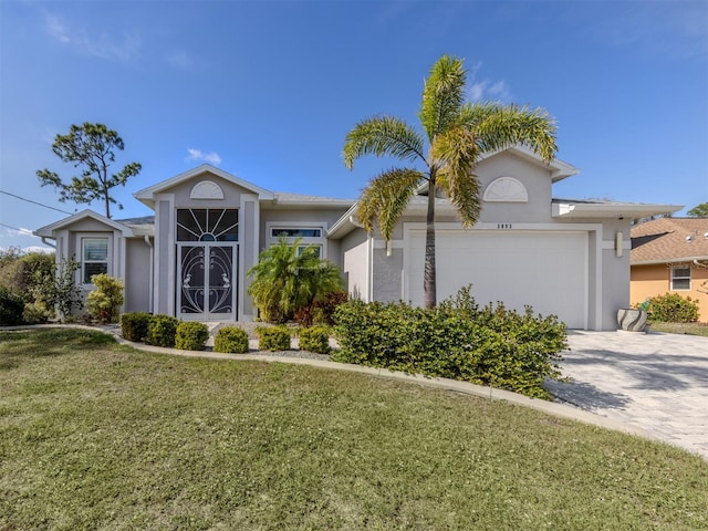 view of front facade with a front yard, decorative driveway, an attached garage, and stucco siding