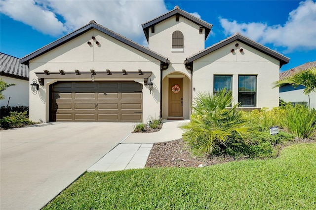 mediterranean / spanish house featuring concrete driveway, an attached garage, and stucco siding