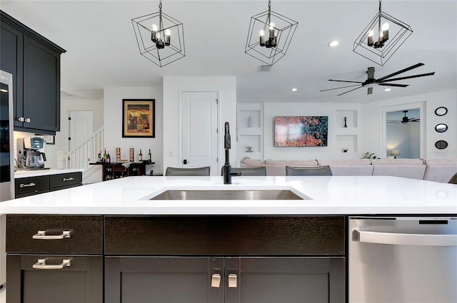 kitchen featuring dishwasher, light countertops, open floor plan, and a sink