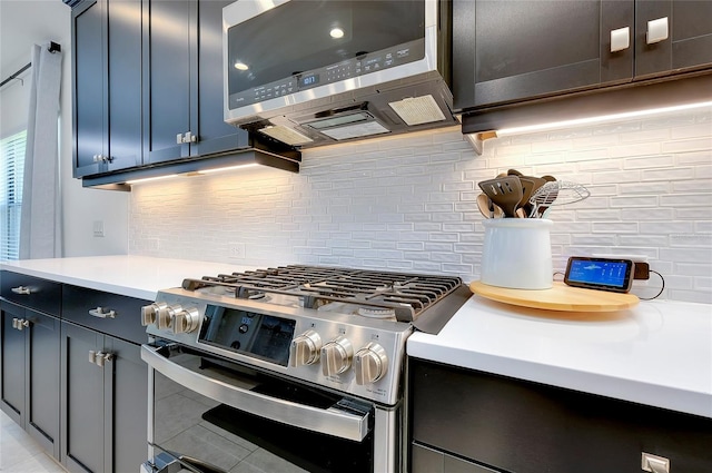 kitchen featuring stainless steel appliances, light countertops, and decorative backsplash