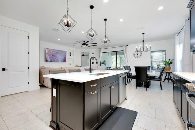 kitchen featuring dishwasher, open floor plan, light countertops, a sink, and light tile patterned flooring