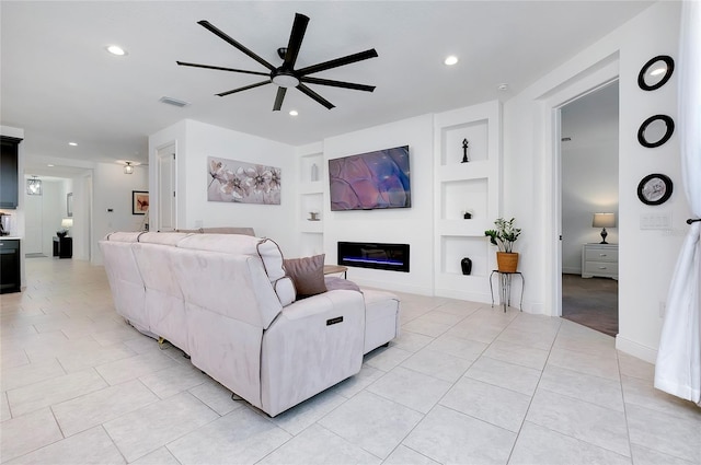 living area with light tile patterned floors, built in shelves, recessed lighting, visible vents, and a glass covered fireplace