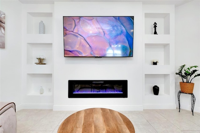 interior details featuring built in shelves, baseboards, and a glass covered fireplace