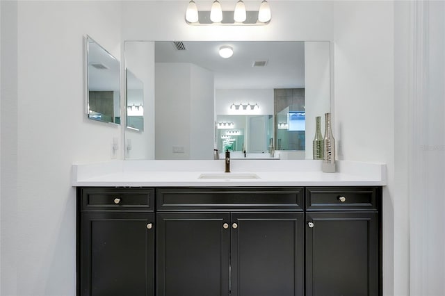 bathroom featuring visible vents, a shower with shower door, and vanity