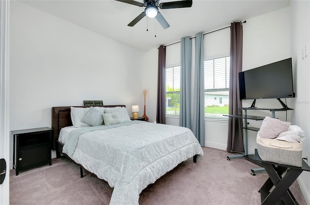 bedroom featuring ceiling fan, baseboards, and light colored carpet