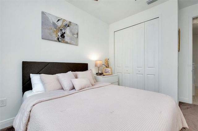 carpeted bedroom with a closet, visible vents, and baseboards