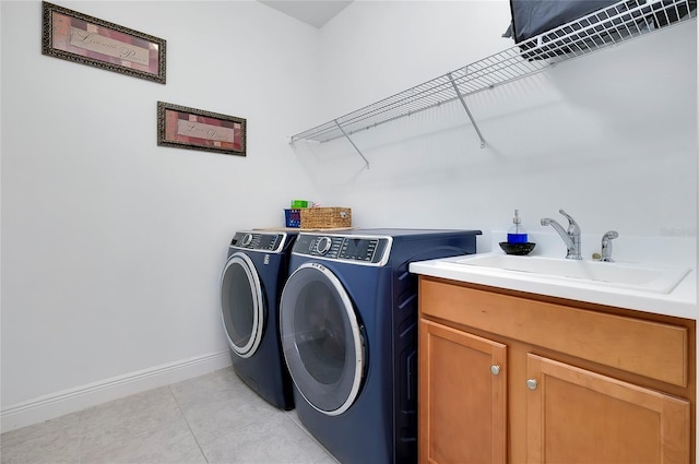 laundry room with cabinet space, baseboards, independent washer and dryer, a sink, and light tile patterned flooring