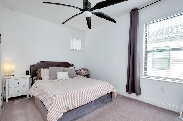 bedroom featuring light carpet, ceiling fan, and baseboards