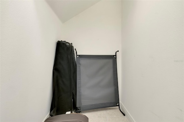 interior space featuring lofted ceiling and baseboards