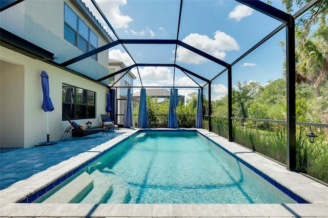 outdoor pool with glass enclosure and a patio area