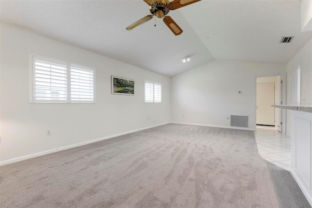 1915 Pebble Beach Ct, Venice, FL 34293 - unfurnished living room featuring light carpet, a ceiling fan, vaulted ceiling, and baseboards