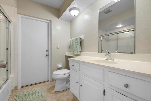 1915 Pebble Beach Ct, Venice, FL 34293 - full bath with toilet, vanity, tile patterned flooring, shower / bath combination with glass door, and a textured wall