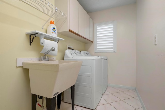 1915 Pebble Beach Ct, Venice, FL 34293 - laundry room featuring cabinet space, washer and dryer, light tile patterned flooring, and baseboards