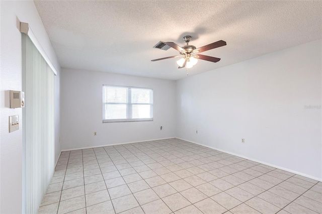 empty room with ceiling fan and a textured ceiling