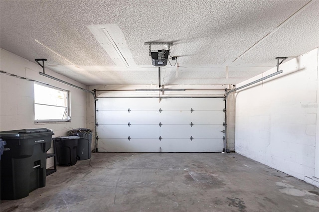 garage featuring concrete block wall and a garage door opener