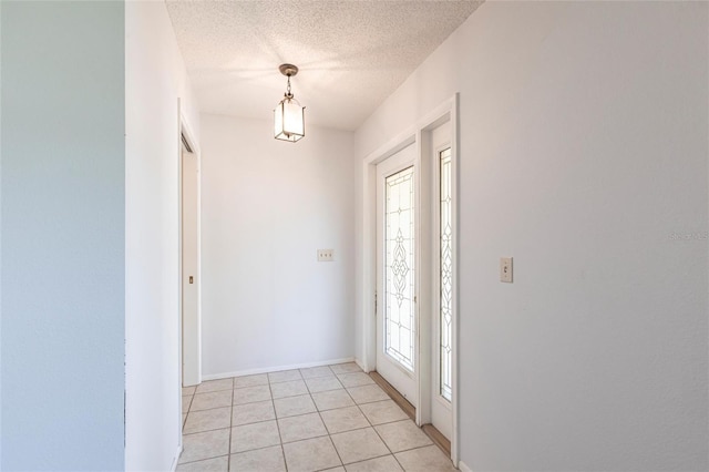 entrance foyer featuring a textured ceiling and light tile patterned floors