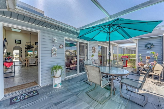 wooden deck with a lanai, outdoor dining space, and a patio