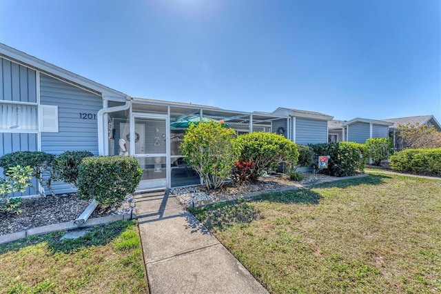 view of front of home with a front lawn and a sunroom