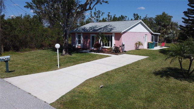 ranch-style house featuring a front lawn and stucco siding