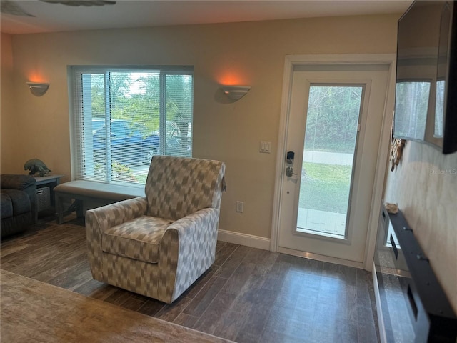 sitting room with dark wood-style flooring and baseboards