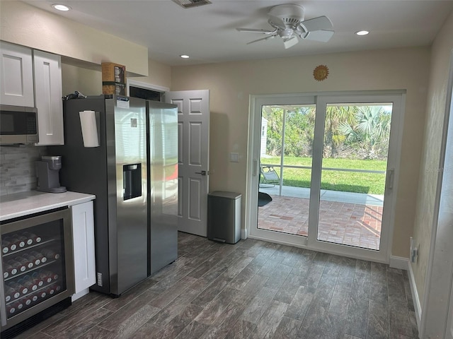 kitchen with wine cooler, recessed lighting, light countertops, appliances with stainless steel finishes, and dark wood-type flooring