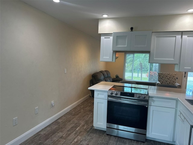 kitchen with light countertops, a peninsula, white cabinets, and stainless steel electric stove