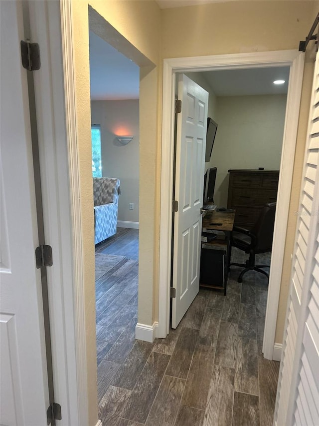 corridor featuring baseboards and wood tiled floor