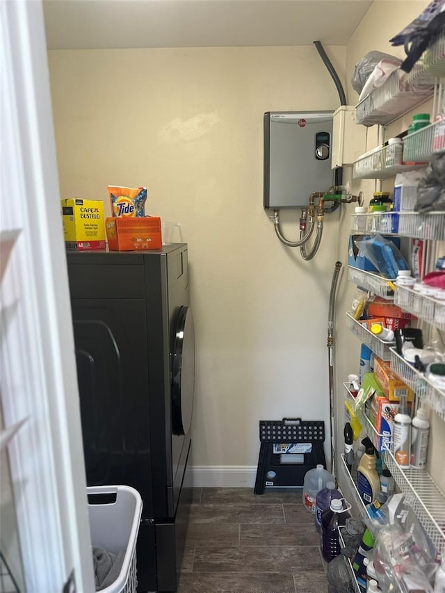 clothes washing area with wood finish floors, laundry area, washer and clothes dryer, and baseboards