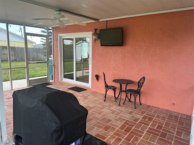 view of patio featuring fence, grilling area, and a ceiling fan