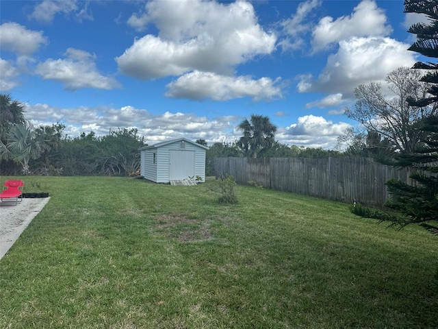 view of yard with a storage shed, an outbuilding, and fence