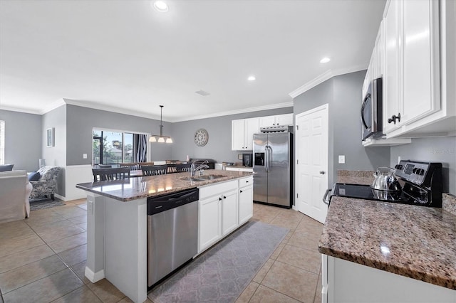 kitchen featuring appliances with stainless steel finishes, a kitchen island with sink, pendant lighting, and white cabinets