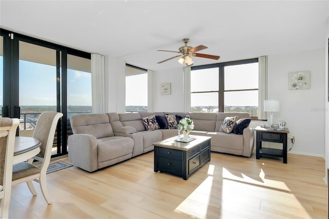 living room with light hardwood / wood-style flooring and ceiling fan