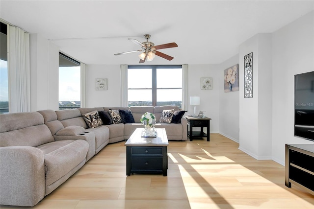 living room featuring ceiling fan, a healthy amount of sunlight, and light hardwood / wood-style floors