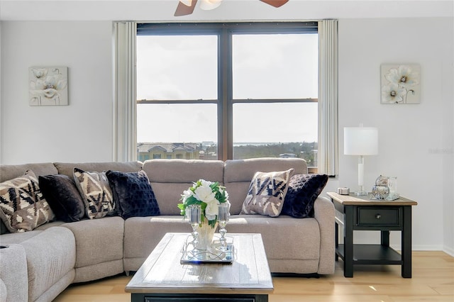 living room with light hardwood / wood-style flooring and ceiling fan