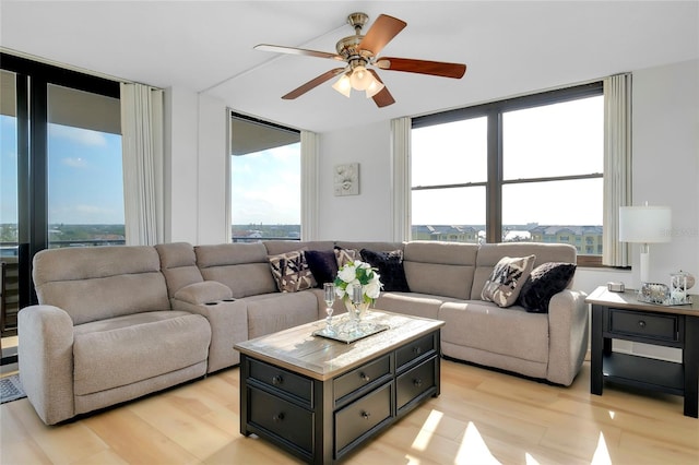 living room with ceiling fan and light wood-type flooring