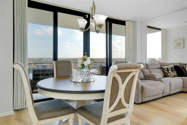 dining space with an inviting chandelier, hardwood / wood-style floors, and a wall of windows