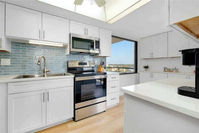 kitchen featuring sink, ceiling fan, backsplash, stainless steel appliances, and white cabinets