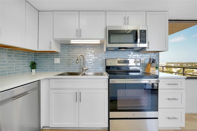 kitchen featuring white cabinetry, stainless steel appliances, sink, and backsplash