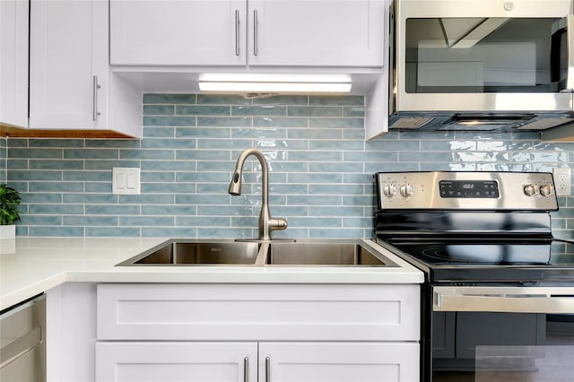 kitchen featuring tasteful backsplash, appliances with stainless steel finishes, sink, and white cabinets