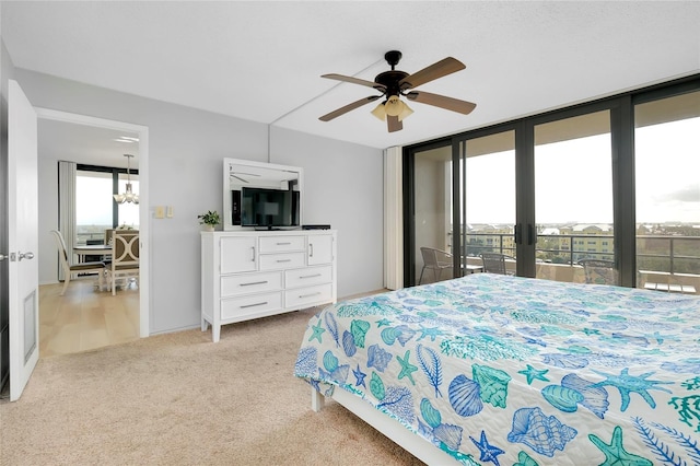 bedroom featuring access to outside, light colored carpet, expansive windows, and ceiling fan