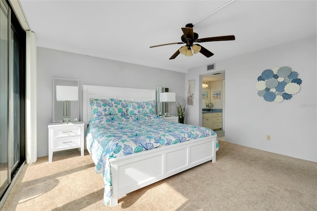 carpeted bedroom with ceiling fan and connected bathroom