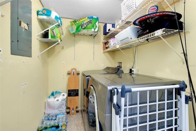 laundry area with electric panel, independent washer and dryer, and a textured ceiling