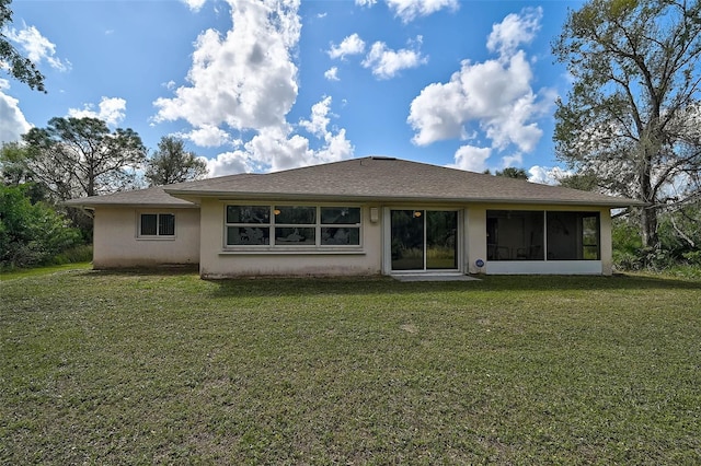 back of property featuring a sunroom and a lawn