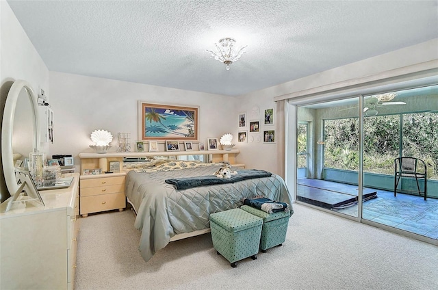 carpeted bedroom with a textured ceiling and access to outside