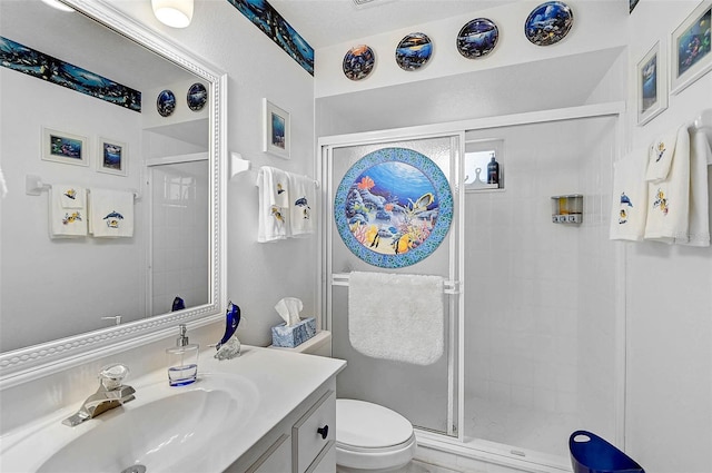 bathroom featuring vanity, toilet, and a shower with shower door