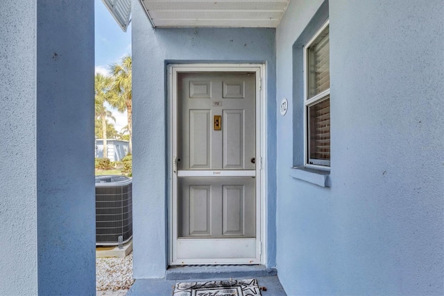 view of exterior entry with central air condition unit